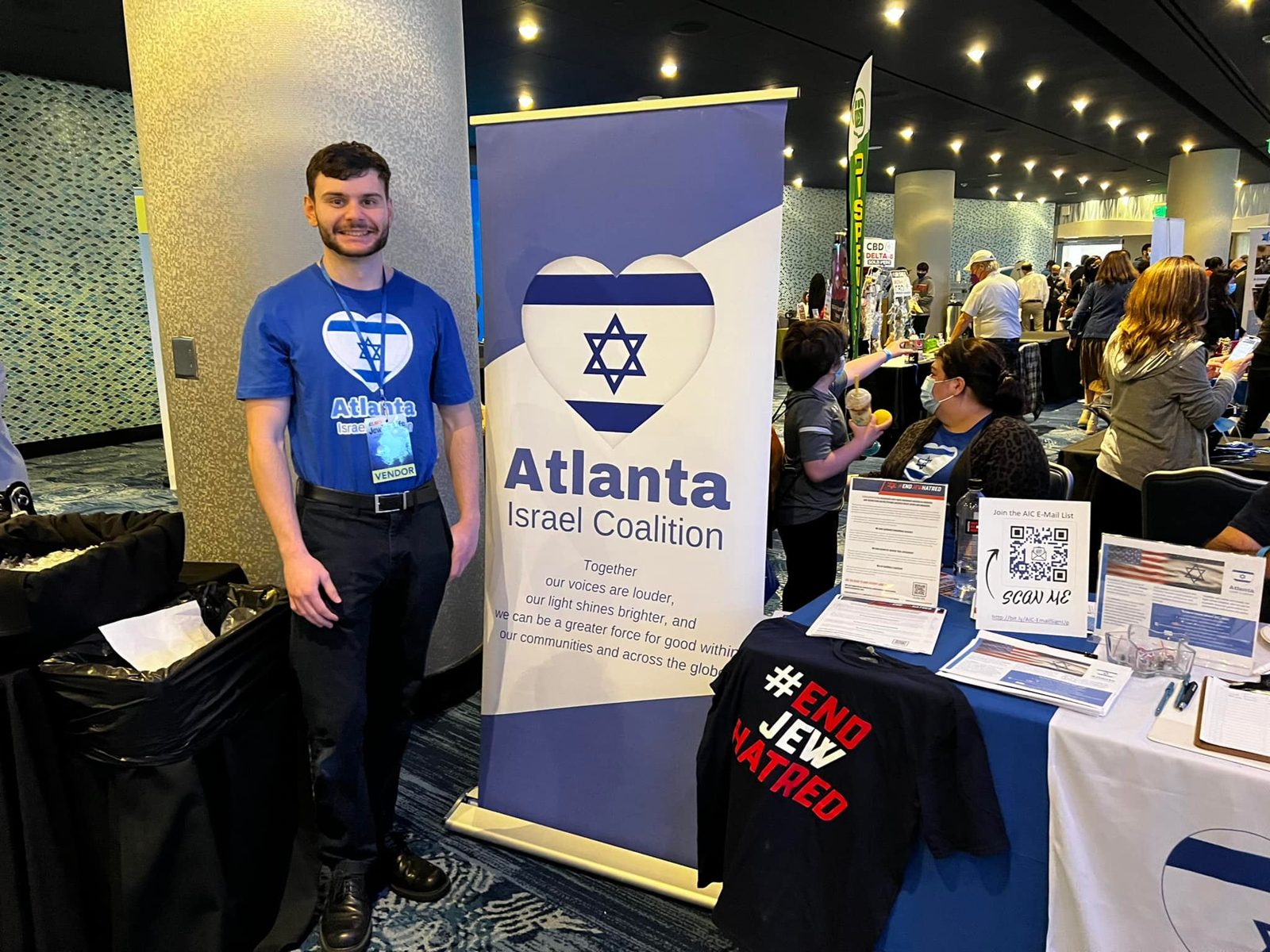 An AIC volunteer at the Atlanta Israel Coalition table and banner at the Atlanta Jewish Life Festival.
